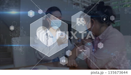 Administering vaccine into patient arm at clinic desk with syringe, stethoscope, digital icons 135673644