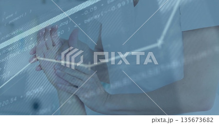 Supporting clinician wearing white scrub holding patient's wrist in clinic, with digital overlays 135673682