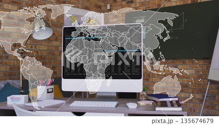 Displaying monitor showing code with world map overlay on desk in home office, with chalkboard 135674679