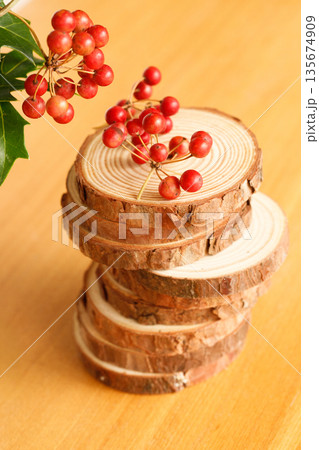 積み重なるウッドスライスと赤い実サンキライ 135674909