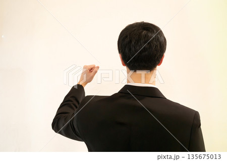 ガッツポーズをするビジネスマンの男性の後ろ姿 135675013