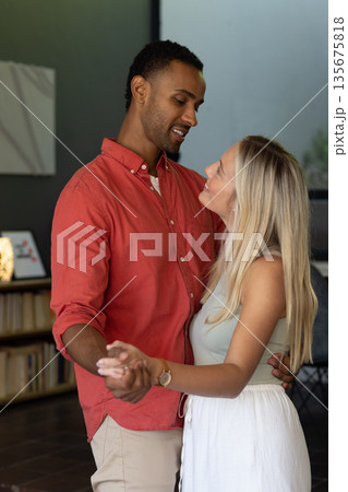 Couple dancing closely at home, sharing joyful moments and smiling warmly Couple dancing closely at home, sharing joyful moments and smiling warmly 135675818