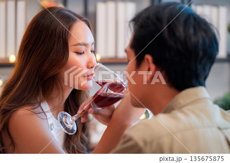Happy asian couple drinking wine during romantic dinner, celebrating Valentine's Day. Happy asian couple drinking wine during romantic dinner, celebrating Valentine's Day. 135675875