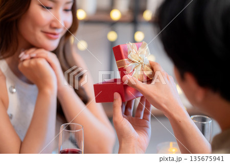Romantic asian man giving gift box to girlfriend with excited, surprise for Valentine's Day. Romantic asian man giving gift box to girlfriend with excited, surprise for Valentine's Day. 135675941