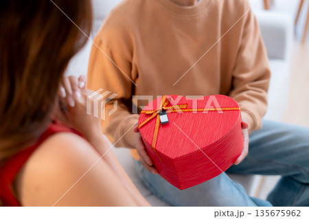Happy asian man giving heart gift box to girlfriend celebrating Valentine's Day or anniversary. Happy asian man giving heart gift box to girlfriend celebrating Valentine's Day or anniversary. 135675962