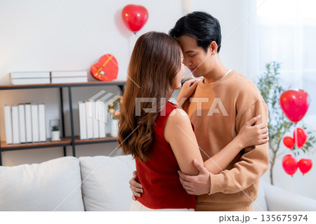 Romantic asian couple standing with head touch, feeling love and tenderness at home. 135675974
