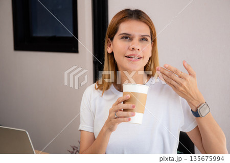 Happiness young caucasian businesswoman drinking coffee while working on laptop computer. Happiness young caucasian businesswoman drinking coffee while working on laptop computer. 135675994