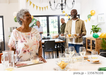 Celebrating at home, African American family with food and decorations, smiling joyfully 135676108
