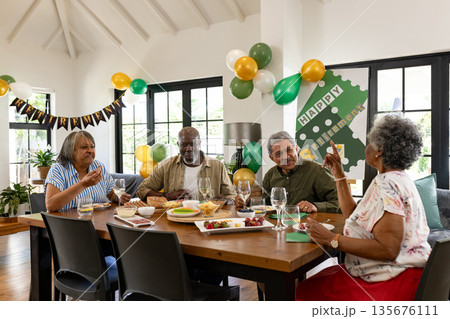 Celebrating retirement, African American seniors with food and decorations at home 135676111
