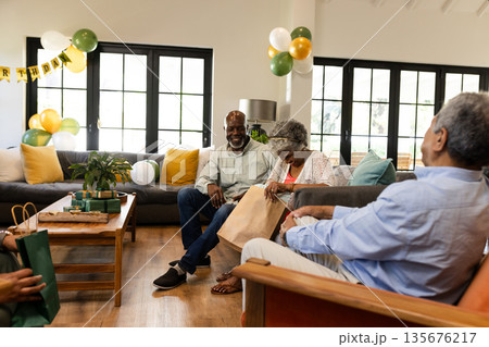 Exchanging gifts, family celebrating birthday at home, sharing joyful moments together Exchanging gifts, family celebrating birthday at home, sharing joyful moments together 135676217
