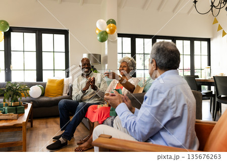 Celebrating together at home, elderly friends clapping in festive atmosphere 135676263