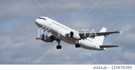 Airplane take off on the blue sky, with white clouds. Aircraft flying on sky background. White passenger jet plane in the blue sky. Low angle view of Airplane flying under blue sky, with white clouds 135676389