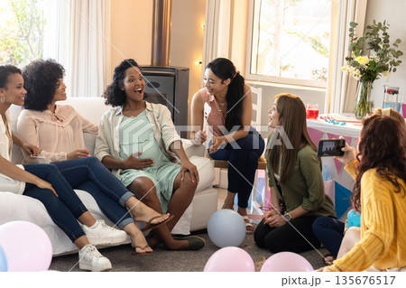 African American woman surrounded by friends celebrating baby shower at home African American woman surrounded by friends celebrating baby shower at home 135676517