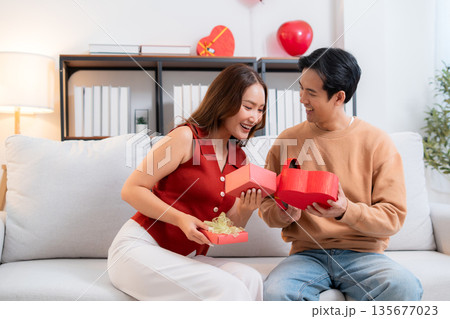 Romantic asian couple giving and receiving heart gift box for celebrating birthday or holiday. Romantic asian couple giving and receiving heart gift box for celebrating birthday or holiday. 135677023
