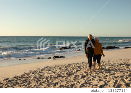 Senior couple walking on the beach, near ocean 135677154