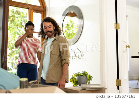 Young diverse couple unpacking boxes in new home, feeling excited and surprised 135677163