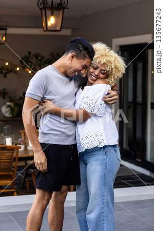 Embracing and laughing joyfully, couple on cozy patio enjoying their time 135677243