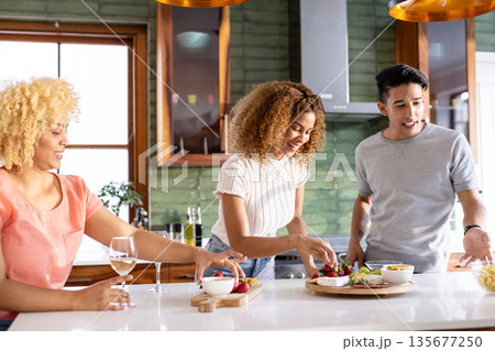 Preparing meal in modern kitchen, Diverse friends sharing conversation and laughter together Preparing meal in modern kitchen, Diverse friends sharing conversation and laughter together 135677250