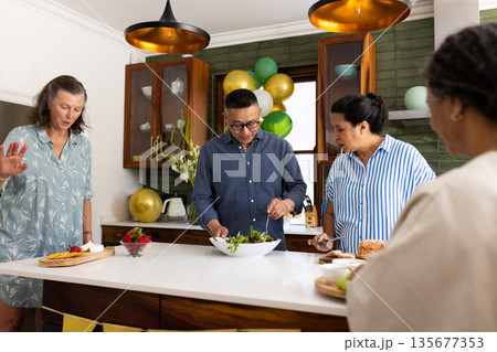 Preparing healthy salad, seniors in modern kitchen having conversation together Preparing healthy salad, seniors in modern kitchen having conversation together 135677353