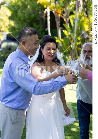 Bride and guests toasting with champagne glasses at outdoor senior wedding celebration 135677358