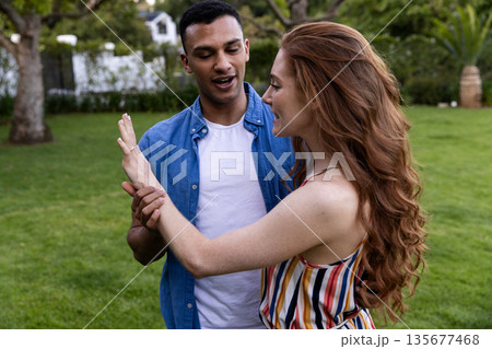 Young couple enjoying playful moment together in lush green park 135677468