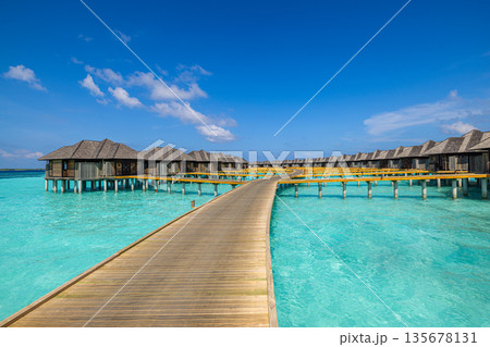 Luxury sunny Maldives island, overwater villas and bungalows, calm turquoise lagoon, tropical paradise, relaxing summer vacation, serene exotic travel destination 135678131