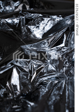 Vertical crumpled foil texture with strong metallic contrast Vertical crumpled foil texture with strong metallic contrast 135678210