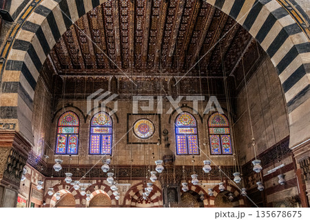 Intricate ceiling design of Sultan Al-Ashraf Qaytbay Mosque. Features geometric patterns and ornate details in gold and brown tones Intricate ceiling design of Sultan Al-Ashraf Qaytbay Mosque. Features geometric patterns and ornate details in gold and brown tones 135678675