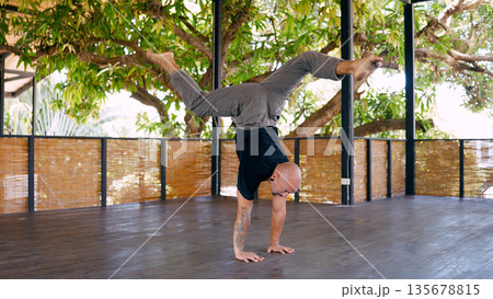 Man performing handstand while training fitness in costa rica Man performing handstand while training fitness in costa rica 135678815