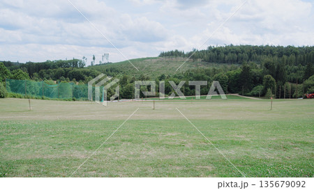 Open practice field with targets, nets and mown grass. Calm rural setting with rolling hills, useful for campaigns about active lifestyle, weekend recreation, team building and summer events. Open practice field with targets, nets and mown grass. Calm rural setting with rolling hills, useful for campaigns about active lifestyle, weekend recreation, team building and summer events. 135679092