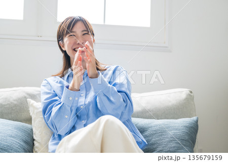 ソファーでくつろいでいる女性 ソファーでくつろいでいる女性 135679159