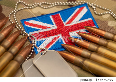 Military ammunition and identification tags on United Kingdom flag background 135679255