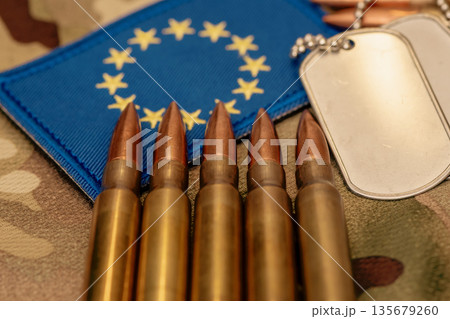 Metal identification tags and cartridges placed near European Union flag. 135679260