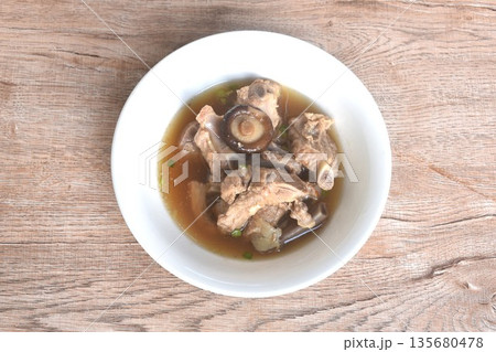 boiled pork bone topping black mushroom in clear Chinese herb soup on bowl boiled pork bone topping black mushroom in clear Chinese herb soup on bowl 135680478