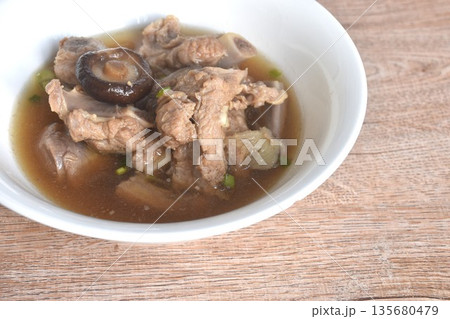 boiled pork bone topping black mushroom in clear Chinese herb soup on bowl  135680479