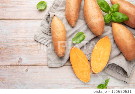 Raw sweet potatoes on wooden background preparing healthy meal 135680631