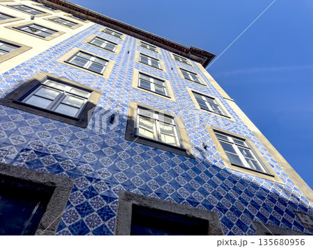 Traditional Portuguese azulejo tiles in blue and colorful geometric patterns, adorning the facade of Traditional Portuguese azulejo tiles in blue and colorful geometric patterns, adorning the facade of 135680956