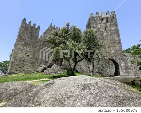 Majestic medieval stone castle with towers and battlements, standing on a scenic hill. Ancient 135680978