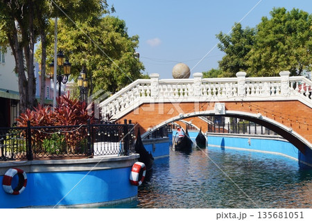 Little Venice in Thailand.Streets and canals of old Venice in Thailand with wooden gondolas, stone bridges, and a blue sky in the background. Little Venice in Thailand.Streets and canals of old Venice in Thailand with wooden gondolas, stone bridges, and a blue sky in the background. 135681051