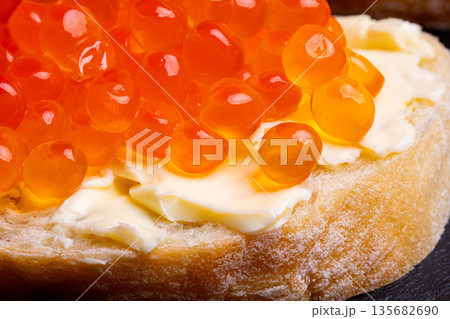 Sandwich with red caviar. Red ikura. Macro shot. 135682690