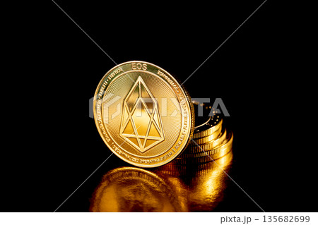 EOS coin cryptocurrency. Gold coins on black background. EOS coin cryptocurrency. Gold coins on black background. 135682699