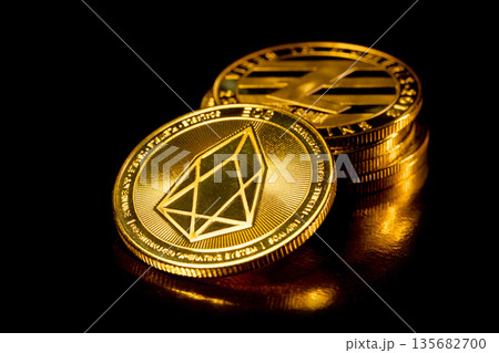 EOS cryptocurrency. Gold coins on black background. EOS cryptocurrency. Gold coins on black background. 135682700