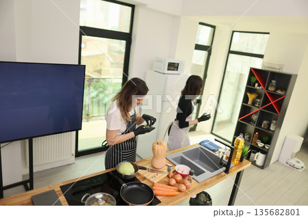 Cooking in a modern kitchen as two chefs prepare fresh ingredients for a delightful meal together Cooking in a modern kitchen as two chefs prepare fresh ingredients for a delightful meal together 135682801
