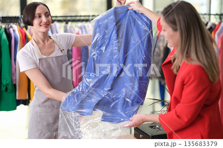 Choosing a stylish outfit at a vibrant boutique during a sunny afternoon 135683379