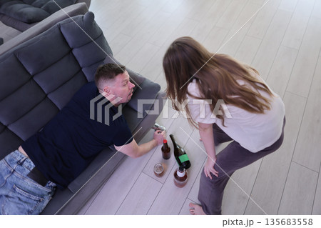 Friends sharing laughter and drinks on a cozy afternoon at home 135683558