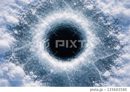 Perfectly Round Ice Fishing Hole in Frozen Lake with Cracked Ice Texture, Winter Nature Background 135683580