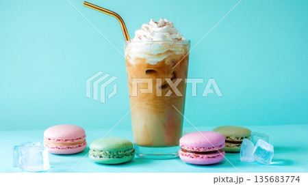 Iced coffee with whipped cream and colorful macarons on pastel background Iced coffee with whipped cream and colorful macarons on pastel background 135683774