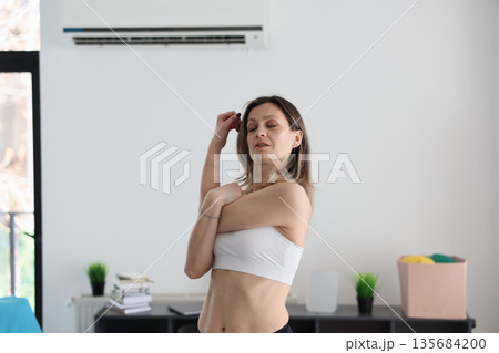 Woman practicing mindfulness and stretching at home in a calm and serene living space Woman practicing mindfulness and stretching at home in a calm and serene living space 135684200