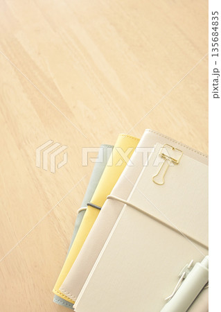 木製の机の上に置かれた手帳とノートとペン 木製の机の上に置かれた手帳とノートとペン 135684835