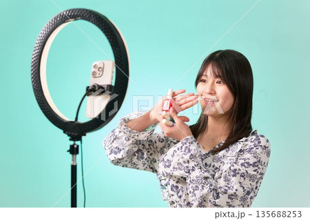 リングライトを使ってコスメのレビュー配信をする女性インフルエンサー 135688253